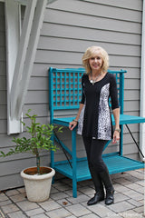 A woman standing beside a flower pot