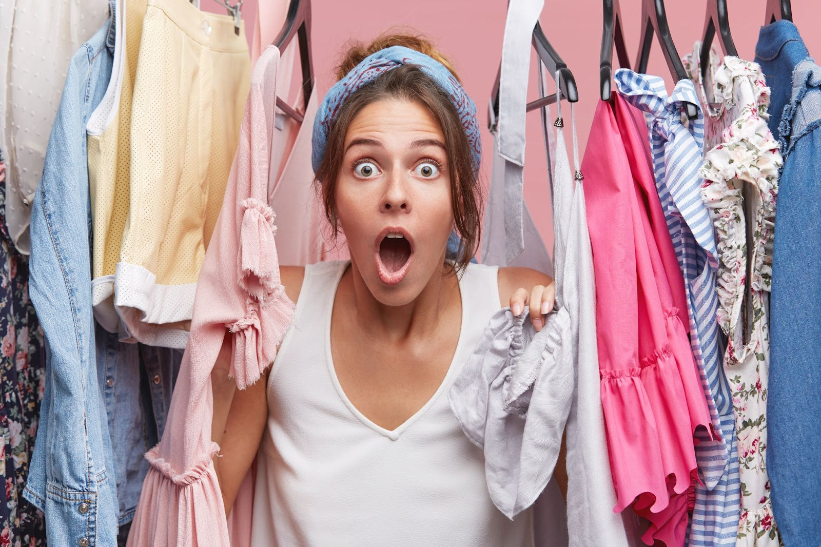 a woman browsing through a closet filled with dress tees, base tees, and camisole for layering