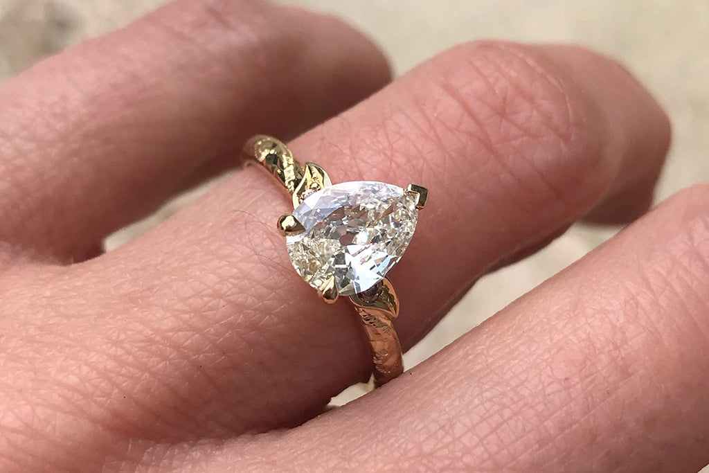 Alex's bespoke solitaire engagement ring, crafted in 18ct recycled yellow gold and set with a pear-shaped antique old-cut diamond