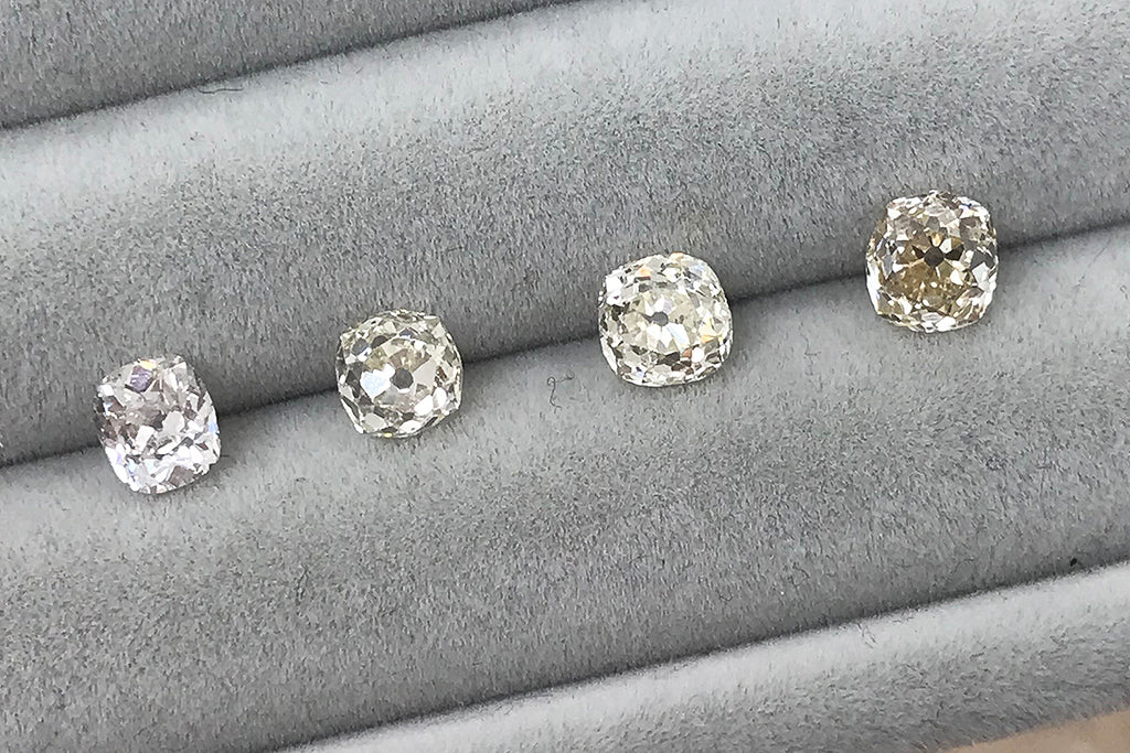 A selection of old mine cut diamonds, lined up on a tray for a bespoke engagement ring client to choose from