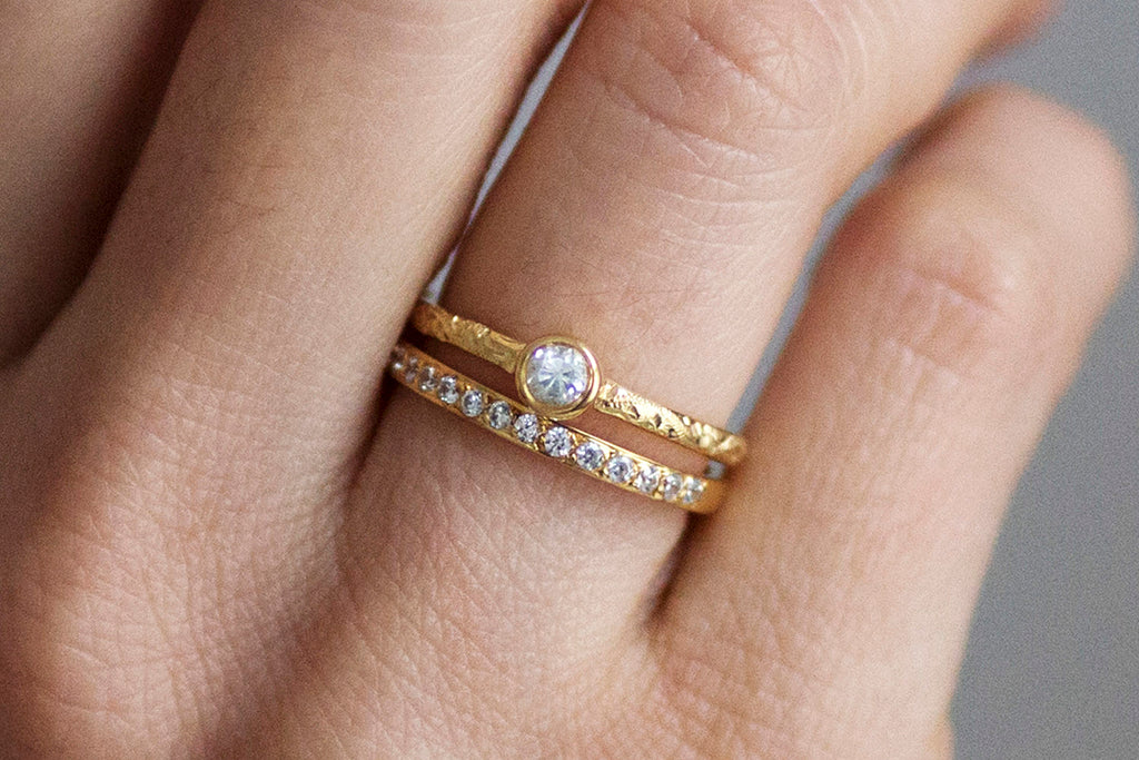 Hera engagement ring and Cherish eternity wedding band together on the ring finger both cast in 18ct recycled yellow gold and set with conflict-free Canadian diamonds