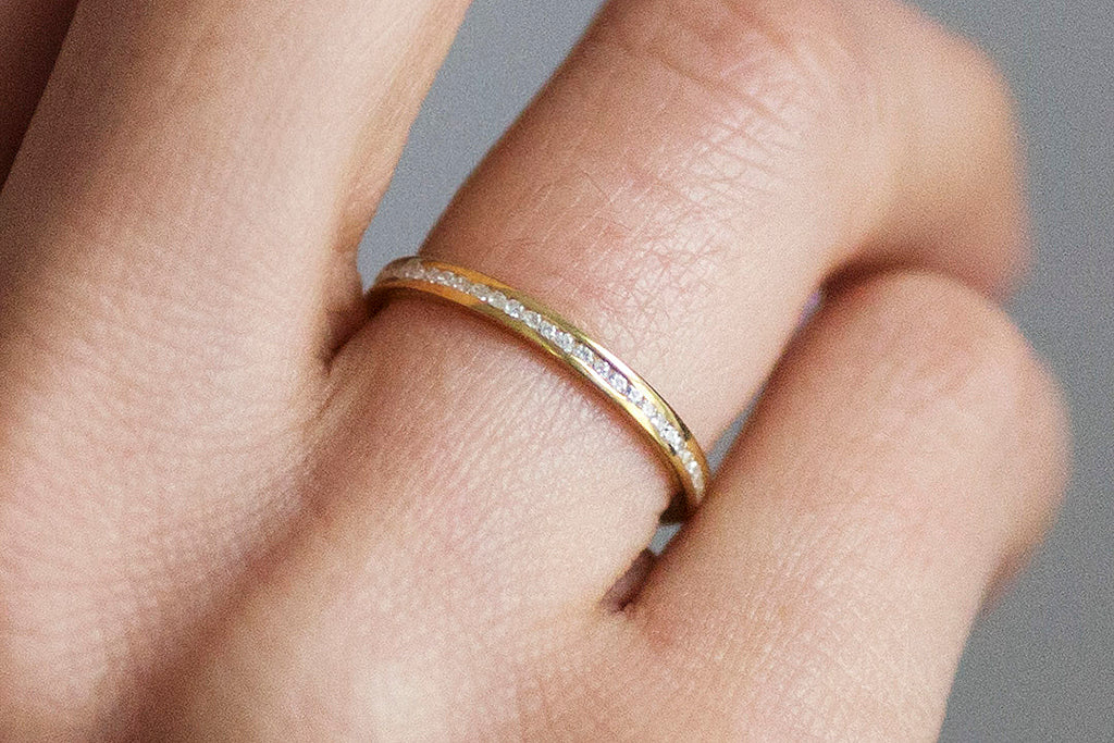 Our channel-set Promise ethical eternity wedding band with small conflict-free diamonds and recycled gold band