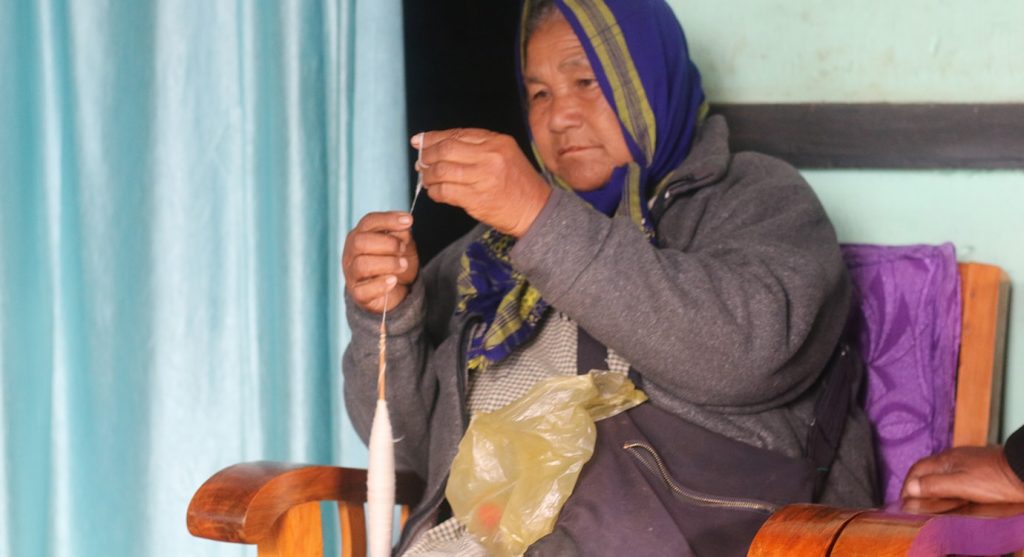 hand spinning organic cotton to weave a traditional Khasi baby wrap