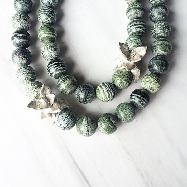 An image of a green silver line jasper gemstone used in Kirsten Muenster Jewelry at the 2015 Holiday Trunk Show at Heath.