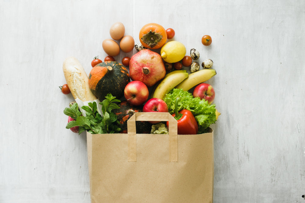 Paper bag full of healthy groceries including fruits and vegetables