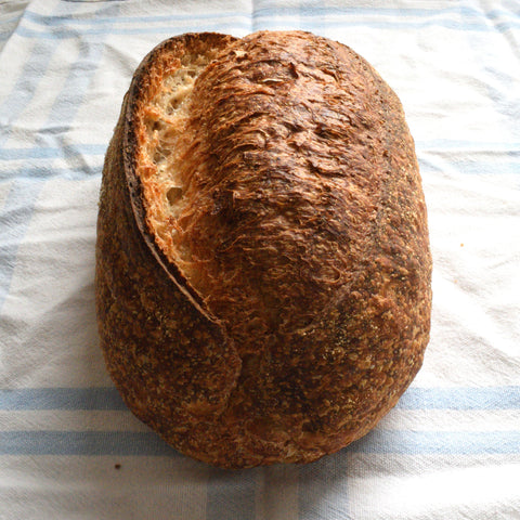 A golden crusted loaf of sourdough bread