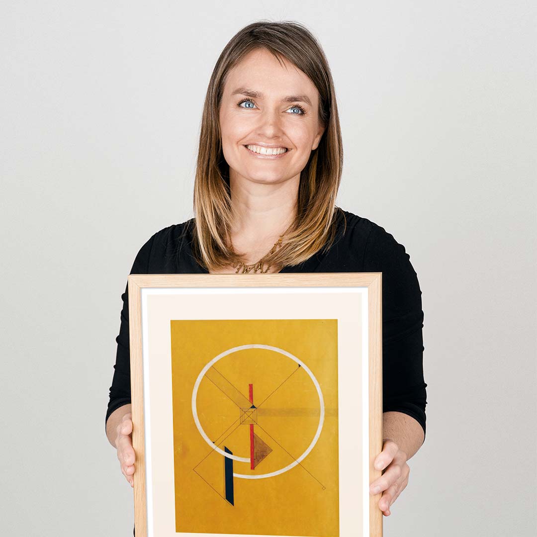 En kvinde fremviser en gylden kunstplakat af El Lissitzky