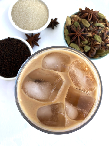 Iced Original Chai Blend, from Shanti Chai & Co. Chai poured over ice, with chai spices, Assam tea and a few star anise pods below.
