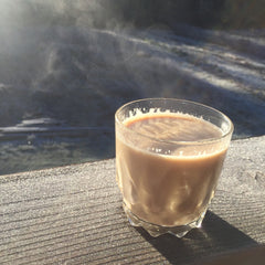 A cup of traditional chai or chai masala sits outside on a sunny winter's day. 