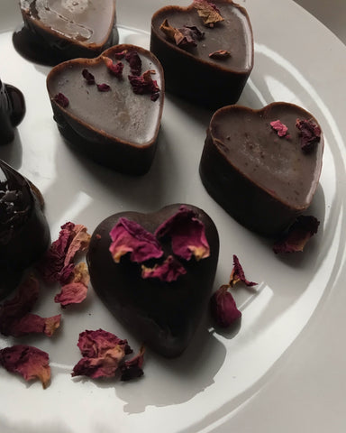A plate of Vanilla and Rose Petal Chocolates, recipe by Shanti Chai & Co, featuring homemade vanilla and red rose petals.