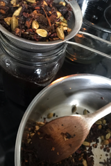 Shanti Chai & Co's DIY chai concentrate recipe, the chai spices and tea are being separated out from the chai tea concentrate using a stainless steel mesh strainer.