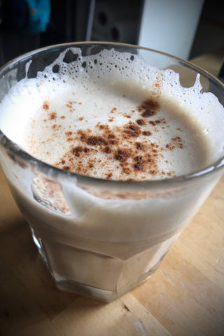 A chai latte made from Shanti Chai & Co's DIY chai concentrate recipe, made with Original Chai Blend. Chai latte is foamy and dusted with ground cinnamon.