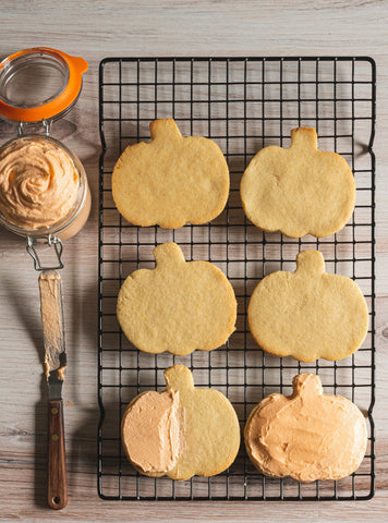 sugar free pumpkin cutout cookies on baking rack with orange frosting