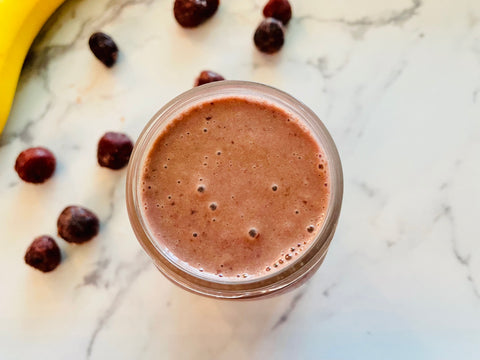 cherry smoothie sitting on a counter in mason jar