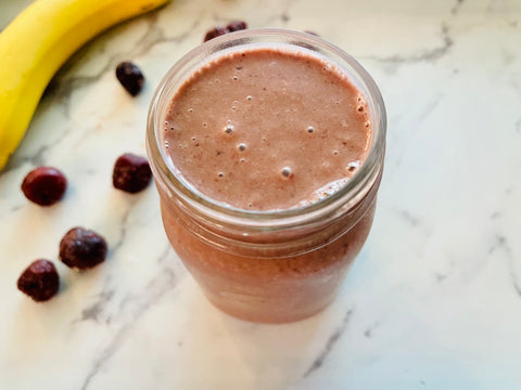 elderberry cherry smoothie with cherries and banana on the counter