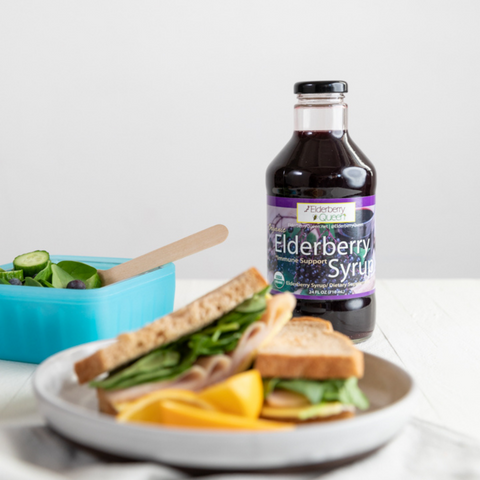 organic elderberry syrup sitting on a table with a healthy sandwich