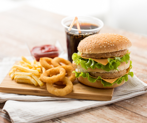 plate of processed foods (burgers, onion rings, soda) on a plate