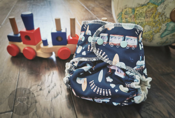 Une couche lavable très unisexe à imprimés de petits trains, laissez-vos enfants explorer! . On aime les trains. Let your baby explore with our waterproof fitted cloth diaper! 