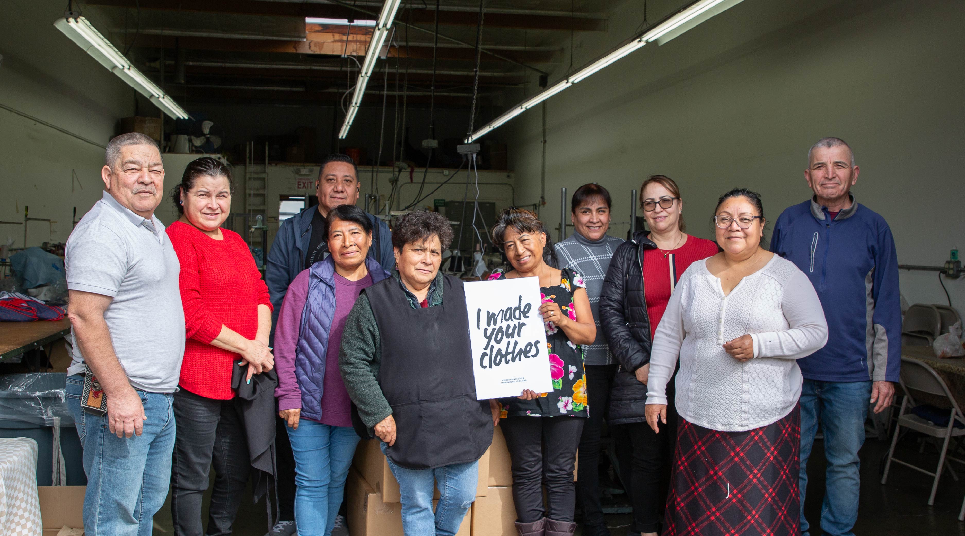 the people and seamstresses at Bella's fashion holding a sign that says I made your clothes