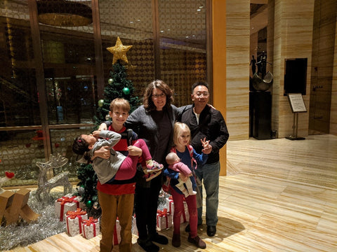 American Family with Adopted Chinese Daughter and Chinese Friend in Luxury Apartment Lobby in China