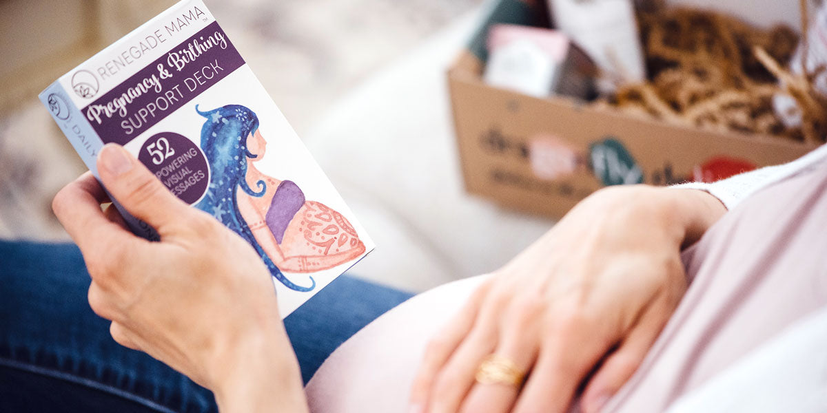 Pregnant woman holding Pregnancy & Birthing Support Deck with Medora gift box in the background