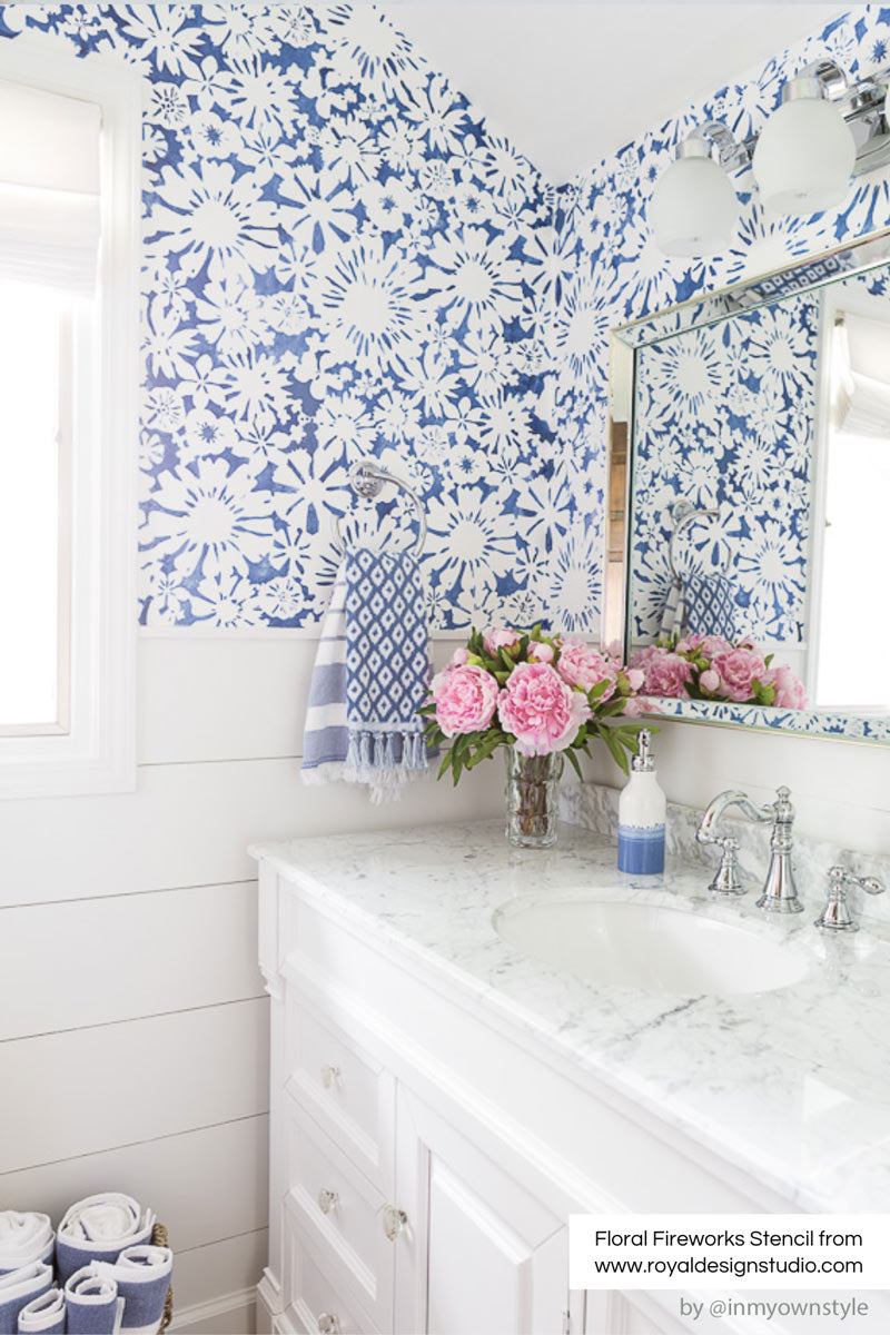 floral stencil with blue paint on bathroom wall