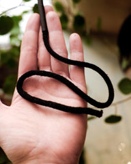 Hand holding a longer black cord