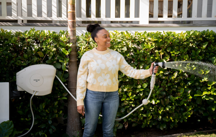 woman using retractable hose reel