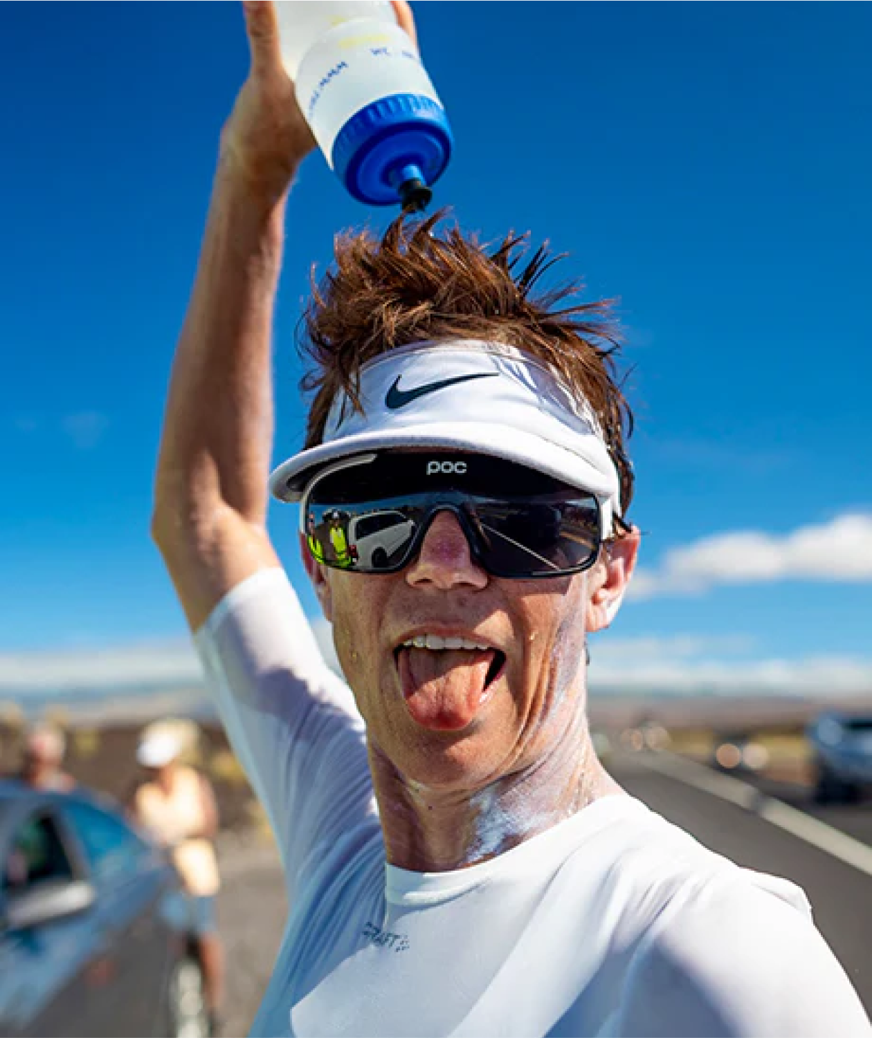 Man cooling off with water during a sunny outdoor activity.