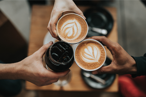 Trois personnes qui trinquent avec du café et du vin