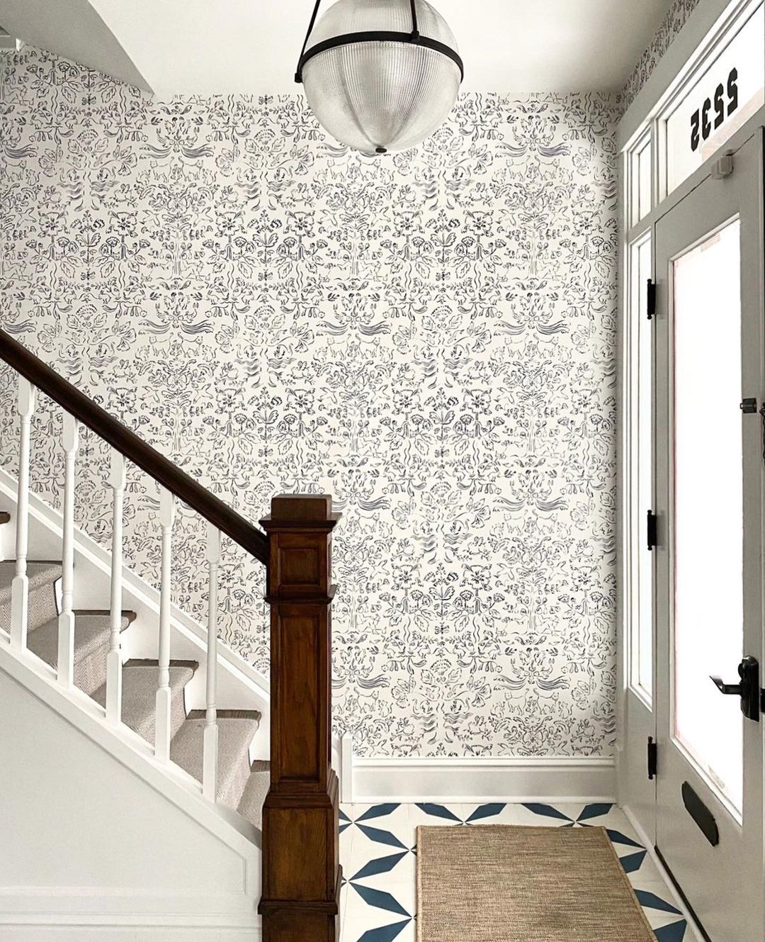 Storyline (Delft Blue) wallpaper in an entry and stairwell, hung by installer First Floor Chicago and designed by Sarah Montgomery Deisgn