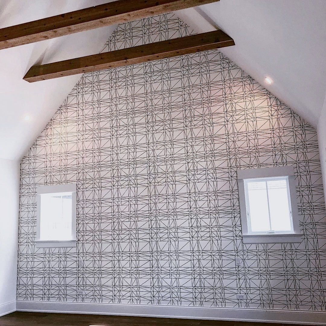 A room with vaulted ceilings featuring Strike (Charcoal) wallpaper installed by First Floor Chicago