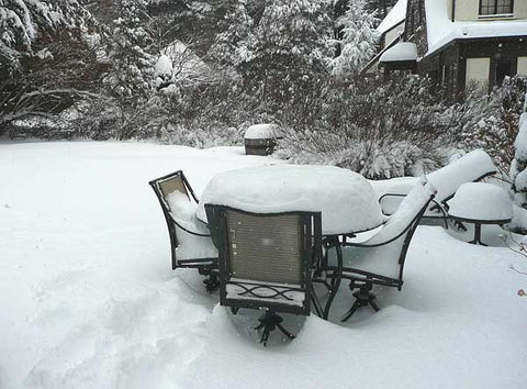 uncovered outdoor patio furniture in snow