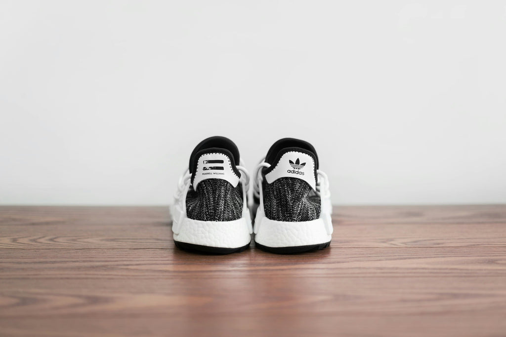 Black and white sneakers on a wooden table with white background