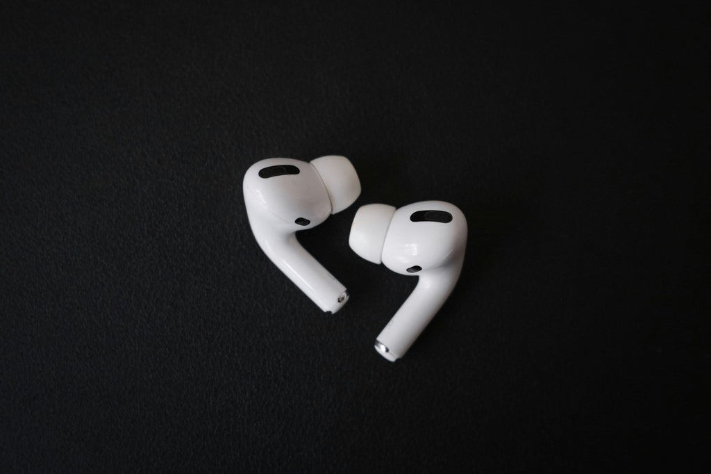 apple airpods pro resting on a black background