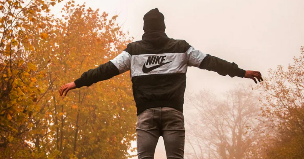 a man jumping in a nike hoodie