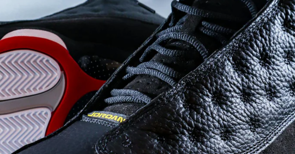 a pair of jordan 13 sneakers black and red