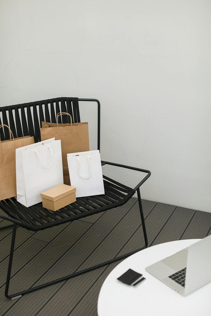 shopping bags on a chair and notebook on a table
