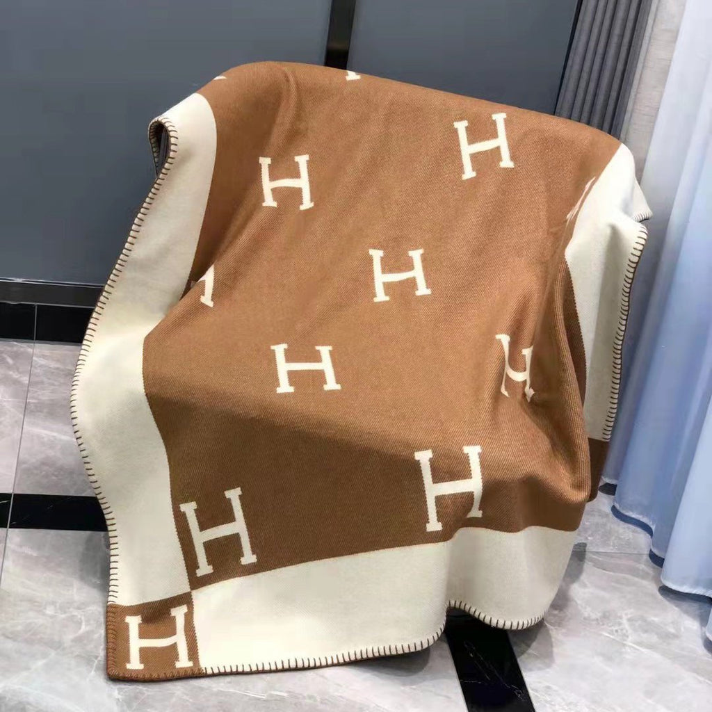 an armchair with a Hermes blanket on top of it