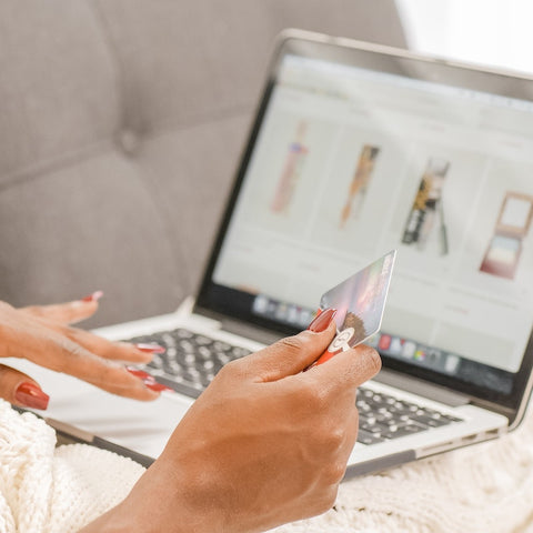 a woman with a credit card in her hand shopping online