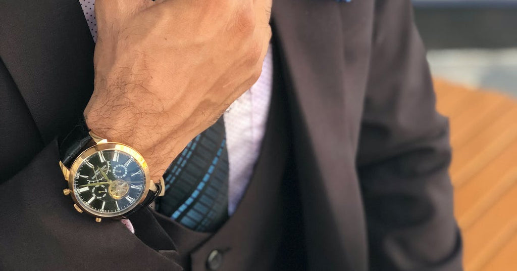 a man in a suit with a watch on his hand