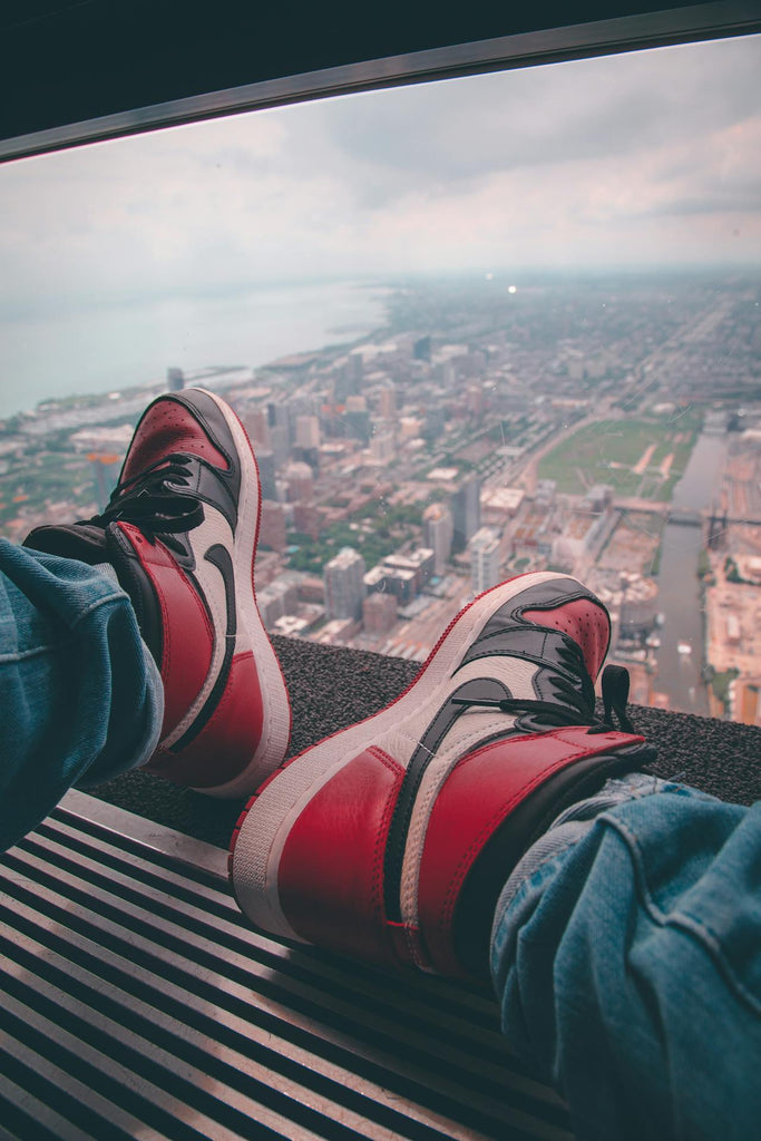 a pair of legs with black and red sneakers