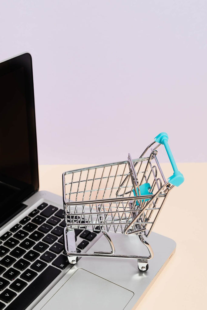 a miniature shopping cart on a laptop