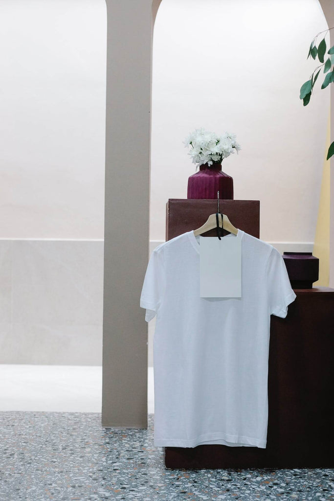 white T-shirt hanging on a counter