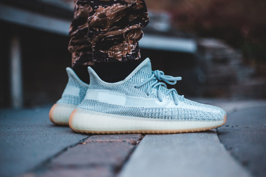 a person wearing yeezy 350 blue tint shoes