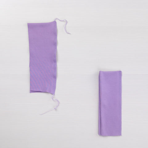 Two scrap pieces of lilac jersey showing different overlocker tension settings.