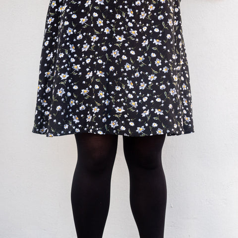 Close up shot of the skirt of Bri's black floral Forget-me-not Valerie Raglan dress