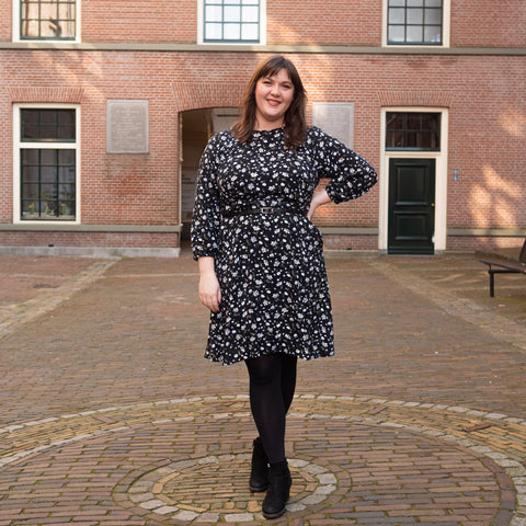 Full body photo of Bri wearing a black floral Forget-me-not Valerie Raglan Dress