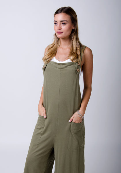 Olive, loose fit jumpsuit with hands in front pockets.
