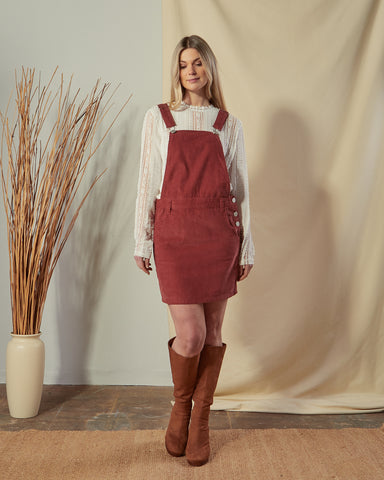 front shot of model wearing a red cord dungaree dress